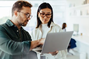 man and woman looking at computer